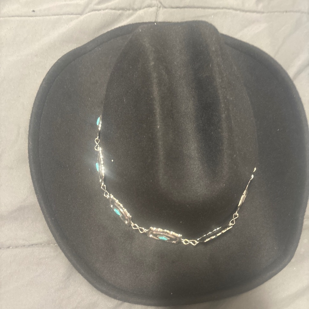 A cow girl black, silver, and teal hat.